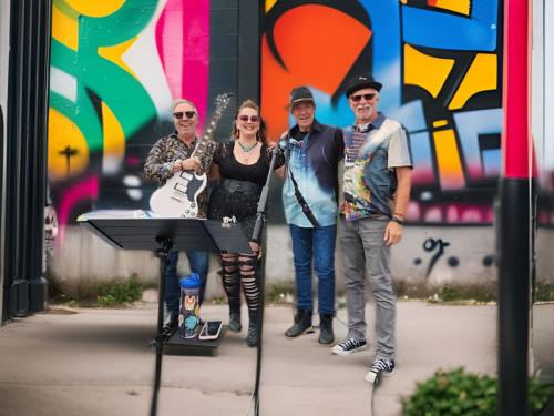 4 people in front of colorful graffiti wall