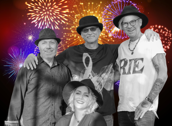 3 men and 1 woman with fireworks in the background